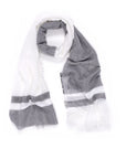 The Farah Silver by SUZI ROHER is a lightweight two-tone scarf: one half solid white, the other dark gray with horizontal white stripes near the ends and soft fringed edges. Made from a cotton-modal-viscose blend.