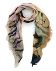 The SUZI ROHER Vogue Covers V.02 is a lightweight, multicolored scarf featuring abstract patterns in beige, green, black, and purple. Loosely looped with frayed edges, it’s timeless wearable art inspired by Vintage Vogue magazine covers.