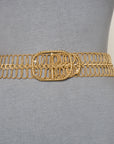 The SUZI ROHER 6826 gold chain-link belt with an ornate, oval clasp is displayed on a gray dress form mannequin against a plain white background.
