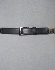 A black stretch elastic SUZI ROHER belt (BELT-8196) with a silver rectangular buckle and black nickel hardware is fastened around a gray dressmaker’s mannequin torso against a plain background.
