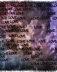 The SUZI ROHER "Love In the Clouds" scarf displays a purple and blue cloudy sky, with the word LOVE in black handwritten lettering repeated throughout.