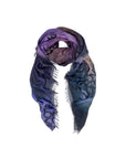 The SUZI ROHER "Love In the Clouds" scarf is a lightweight modal silk accessory with frayed edges, showcasing moody purple, blue, and black gradients and large partially visible black letters across the fabric.