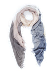 The SUZI ROHER Swept Away-Gray is a lightweight Italian scarf with frayed edges, featuring a gradient of soft beige, gray, and blue tones, shown loosely looped on a white background.