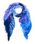 The SUZI ROHER "Eiffel Tower 2.0" scarf, featuring a blue and purple ombré design with frayed edges, is displayed on a white background.