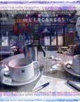 Café interior with coffee cups, saucers, and a pen on a table, featuring the name 'L'Escargot'. A scarf in purple, pink and blues