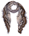 The SUZI ROHER Sechura Desert scarf is a lightweight accessory with frayed edges and geometric patterns in black, brown, navy, and cream, shown loosely looped on a white background.