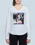 A woman wears The Victoria by SUZI ROHER, a slim-fit, long-sleeve cotton V-neck tee with a vibrant graphic of a woman's face and the words "BIZZARE" at the top and "ART" at the bottom, set against a light background.