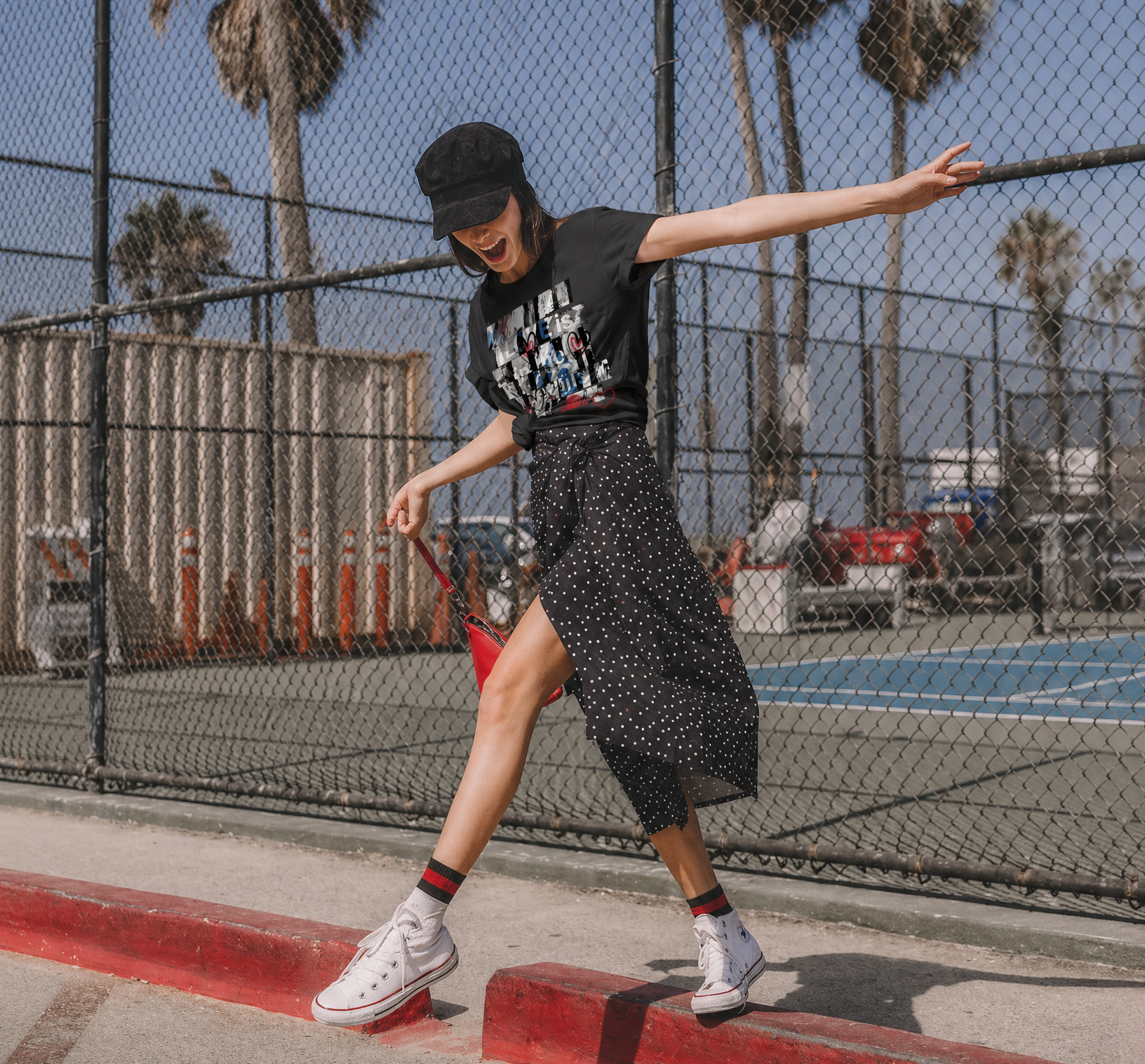 women warning a SUZI ROHER graphic tee shirt, about to cross a street
