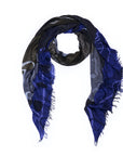 The SUZI ROHER Style Icon scarf features a dark blue and black palette with subtle patterns and frayed edges, arranged in a loop on a white background; its understated style perfectly channels the classic tomboy look made famous by Katharine Hepburn.