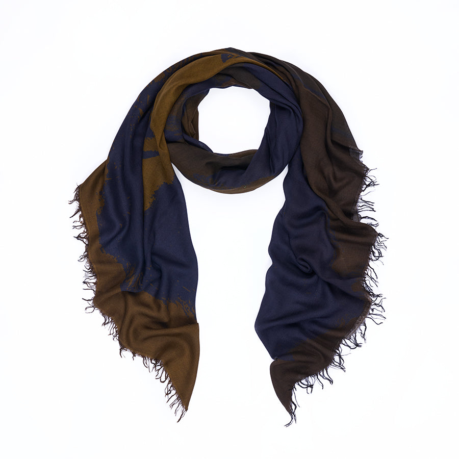 The SUZI ROHER Elizabeth Brown scarf is loosely folded and shown on a white background, featuring original artwork digitally printed in dark blue and brown tones with frayed edges for a unique and timeless look.