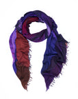 Introducing the AH! scarf by SUZI ROHER—a lightweight accessory with frayed edges, artfully arranged in a twisted loop against a white background. This statement piece features digitally printed original artwork and displays a striking gradient of deep purple, blue, and reddish-brown hues for a truly distinctive touch.