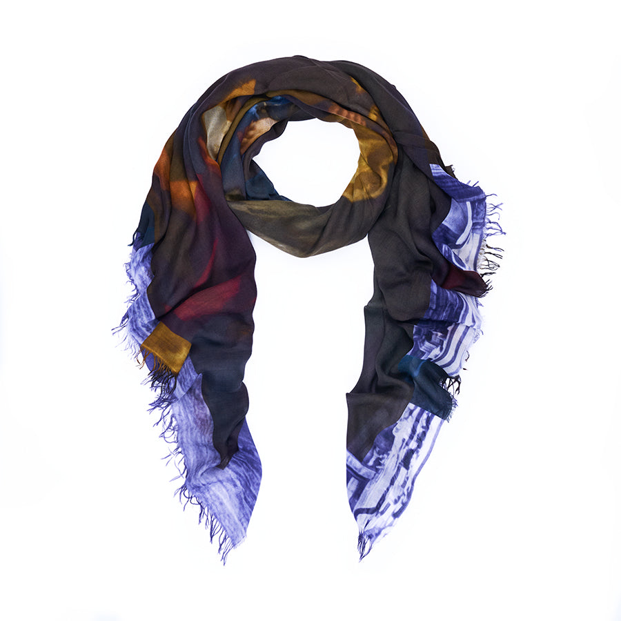 Introducing “Poetry” by SUZI ROHER: a lightweight scarf featuring original abstract artwork in purple, yellow, red, and blue tones. Digitally printed and finished in Italy with frayed edges, Poetry is displayed arranged in a loose loop on a white background.