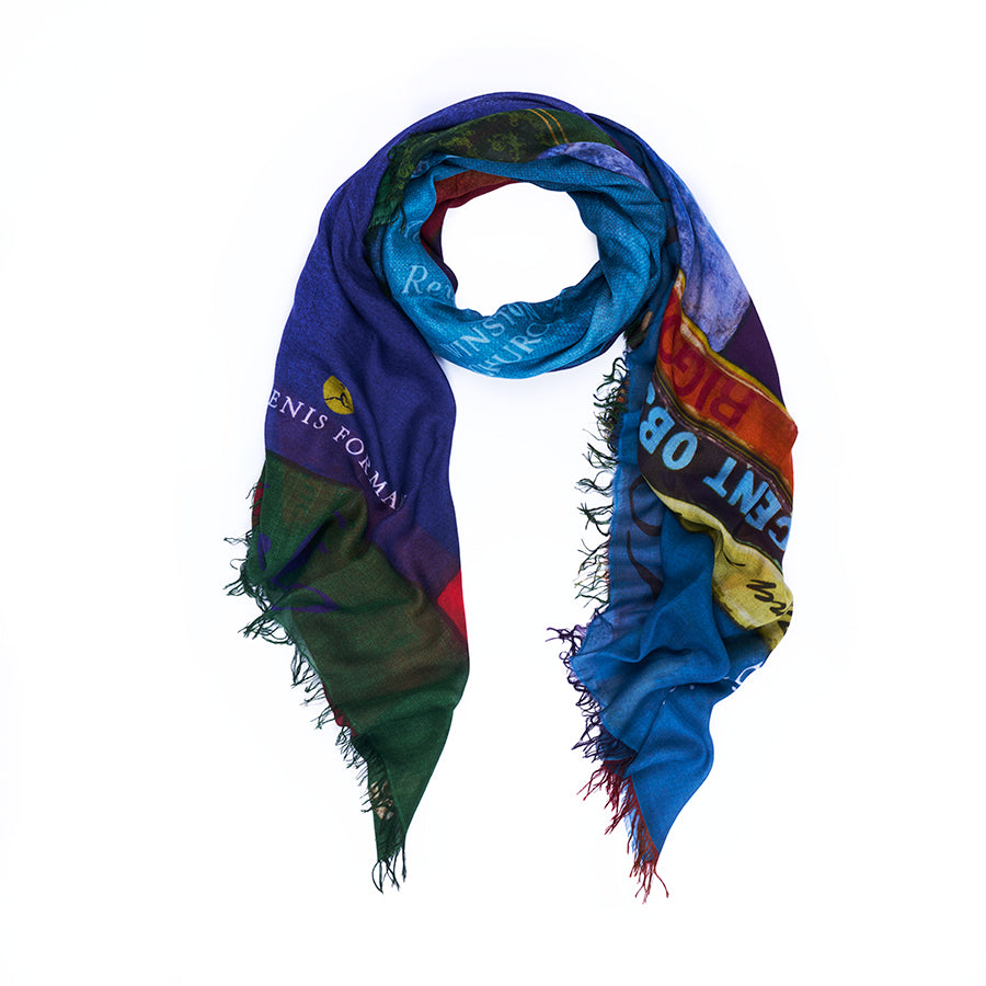 The “Opera” scarf by SUZI ROHER is a colorful rectangular accessory with frayed edges, featuring abstract patterns and partially visible text in a range of hues. Digitally printed from original artwork, it is shown arranged in a loose loop on a white background.