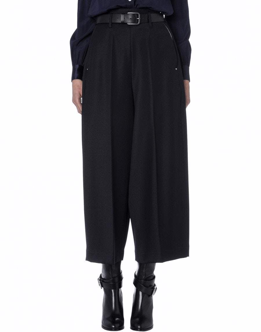 Someone is wearing Sleek high-waisted wide-leg tailored cropped pants with a belt from High, styled with black heeled ankle boots and a dark long-sleeve top. Only the lower body is visible.