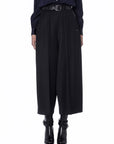 Someone is wearing Sleek high-waisted wide-leg tailored cropped pants with a belt from High, styled with black heeled ankle boots and a dark long-sleeve top. Only the lower body is visible.