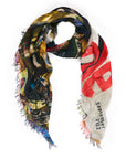 The SUZI ROHER Ensemble scarf, crafted in Italy from luxurious modal silk, showcases abstract patterns, bold red text, and "September 2022" on one end, finished with colorful frayed edges.