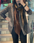 Person taking a mirror selfie wearing a plaid jacket, scarf, and dark pants.