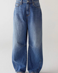 Wearing SHAFT's Barrel Patriot Jeans—high-waisted, wide-leg blue denim with pleats, visible seams, and subtle fading—this person stands against a plain light background with only their lower body shown.