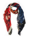 The SUZI ROHER Daily Planet scarf is a lightweight modal silk accessory with frayed edges, showcasing an abstract mix of red, black, blue, and beige. Styled in a loose loop on a white background. Made in Italy.