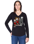 A woman with long brown hair wears The Victoria by SUZI ROHER, a 100% cotton black long-sleeve shirt with a vintage collage design, paired with blue jeans, standing against a white background.