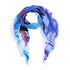 A luxury accessory, the Soul-modal silk scarf by SUZI ROHER features blue, purple, and white abstract patterns with frayed edges in a loose loop. Made in Italy.