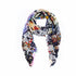 The Marlene Dietrich scarf by SUZI ROHER is a lightweight accessory with frayed edges, showcasing a vibrant collage of images, text, and patterns on a white background.