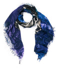 The Excitable scarf by SUZI ROHER is a lightweight luxury Italian accessory with frayed edges, showcasing an abstract pattern in blue, purple, black, and white, styled in a loose loop on a white background.