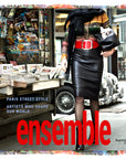 A stylish person in a leather skirt, fishnet stockings, and a colorful modal silk SUZI ROHER Ensemble sweater walks past a newsstand, holding a small dog in an Italian bag. Magazine covers are visible. Text reads: Ensemble – September 2022.