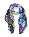Add an artistic accent with SUZI ROHER's "Puzzle of Dreams" scarf—a colorful women's accessory featuring illustrated panels in blue, purple, yellow, black, and gray with symbolic imagery and frayed edges.