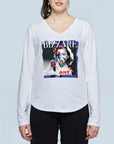 A woman wears The Victoria by SUZI ROHER, a slim fit white V-neck long sleeve cotton tee featuring a colorful pop art portrait with "BIZZARE" at the top and "ART" at the bottom, adding unique flair.