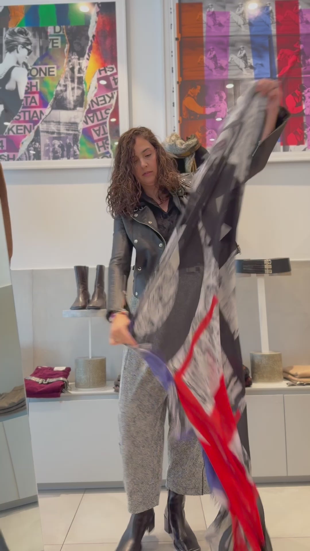 Suzi Roher scarf being opened to show the word WONDERFUL, with a grey black and white background and then colourful red and blue letters. The women puts the wraps on around her neck. 