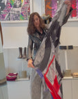 Suzi Roher scarf being opened to show the word WONDERFUL, with a grey black and white background and then colourful red and blue letters. The women puts the wraps on around her neck. 