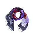 The SUZI ROHER “Lily, Tutti Matti” scarf—a square accessory with frayed edges—features a vibrant abstract design in purple, red, and black hues, reminiscent of original artwork found on an Italian postcard. It is displayed in a loose loop on a white background.