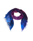 The “Lily, Your Own Pace” scarf by SUZI ROHER features a blue and purple gradient with black printed text, finished with fringed edges. Arranged in a circular shape against a white background, this Italian-made piece showcases original artwork digitally printed onto the fabric.