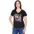 A woman with long brown hair stands facing forward, one hand on her hip, wearing SUZI ROHER's The Viv—a black V-neck T-shirt with a colorful, abstract Breakfast at Tiffany's collage.