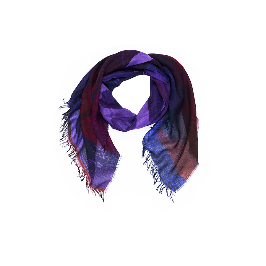 Introducing “Lily, AH!” by SUZI ROHER—a multicolored, digitally printed scarf showcasing vibrant shades of purple, blue, and red. Featuring a soft texture and fringed edges, this statement piece is displayed against a white background and is perfect for elevating any outfit.