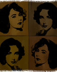 The “Elizabeth Brown” woven textile by SUZI ROHER features four pop art-style portraits of the same woman with dark curly hair, arranged in a 2x2 grid, each rendered in different brown and gold tones. The textile is finished with fringed edges.