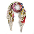 The Flore Francaise scarf by SUZI ROHER features colorful floral prints and text inspired by French botanicals, with frayed edges and a soft, delicate texture, styled in a loose circular shape.