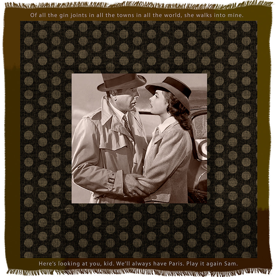 “Play It Again” by SUZI ROHER features a striking black and white image of a man and woman in trench coats and hats tenderly embracing, their eyes locked in a cinematic moment. The scene is framed by film quotes on a rich brown patterned background, capturing the timeless allure of classic movies.