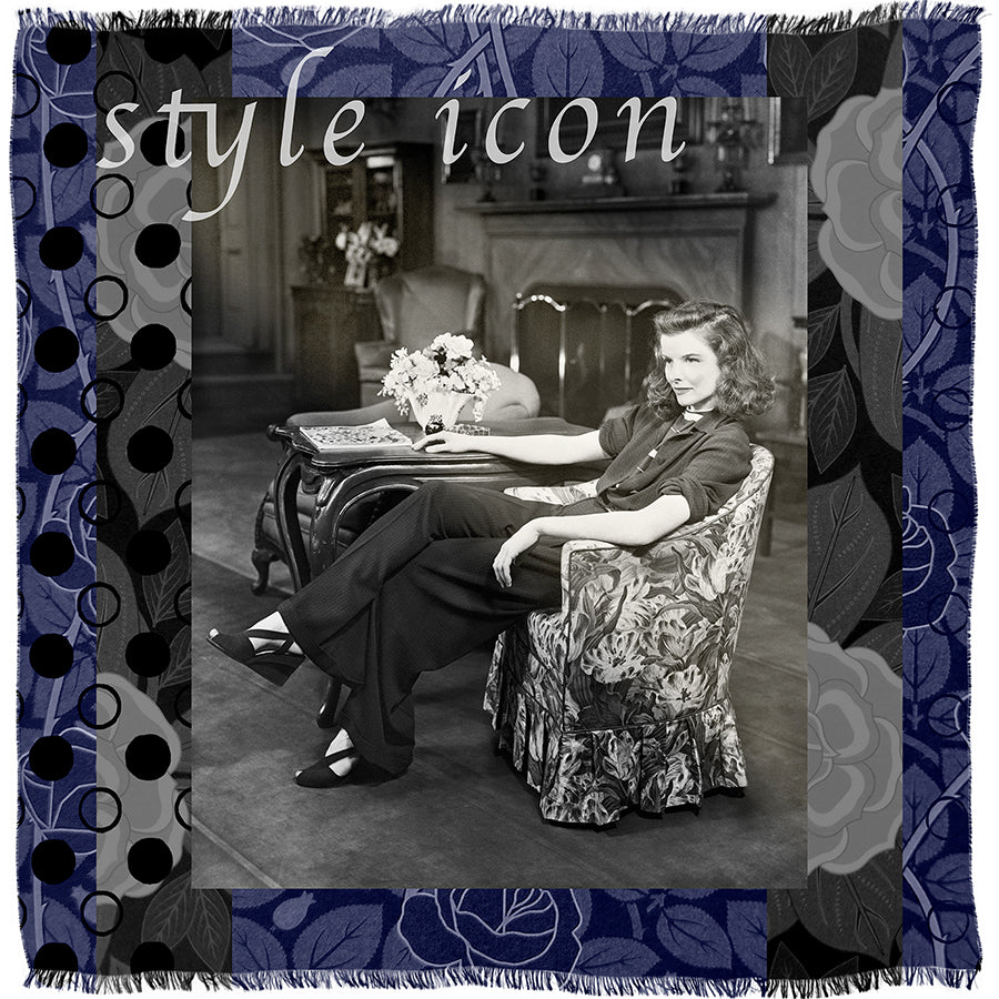 A vintage black-and-white photo features a woman seated in an armchair, framed by a patterned border with “Style Icon” inscribed at the top—a signature piece from SUZI ROHER that captures her relaxed confidence.