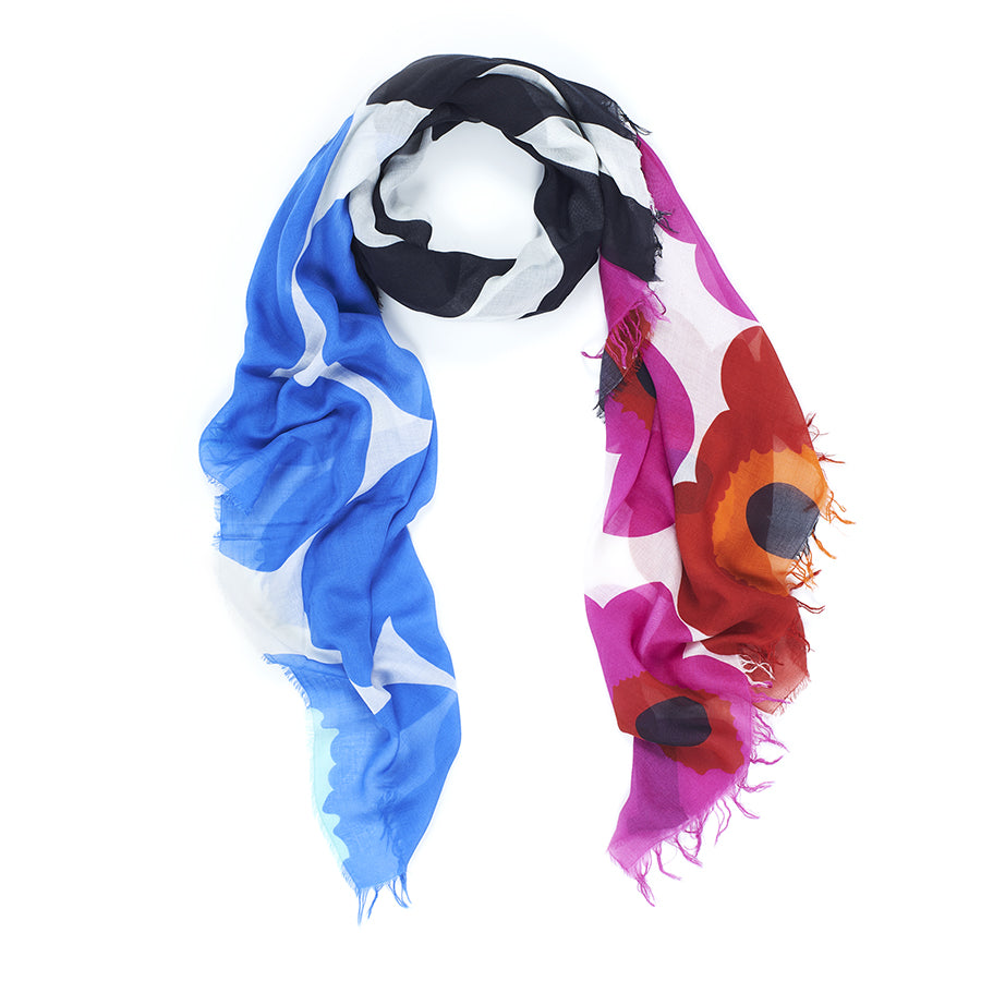 The Suzi Roher "Snap, Crackle, Pop" scarf features bold floral and abstract blue, white, black, red, and pink patterns with frayed edges, arranged in a loose loop on a white background.