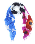 The Suzi Roher "Snap, Crackle, Pop" scarf features bold floral and abstract blue, white, black, red, and pink patterns with frayed edges, arranged in a loose loop on a white background.