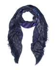The SUZI ROHER "Wild Within" scarf is a dark, lightweight luxury accessory made in Italy, featuring subtle blue, purple, and gray polka dot and plaid patterns with frayed edges, displayed in a loose loop on a white background.