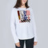 A person wears SUZI ROHER's The Catherine, a white crew neck long sleeve shirt with an abstract checkered red, blue, and yellow graphic, standing against a plain light gray background.