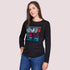 A woman with long brown hair wears SUZI ROHER’s The Catherine: a 100% cotton black crew neck tee with a colorful “captcha” graphic, paired with blue jeans and set against a plain light background.