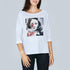 Smiling, a woman wears The Bailey by SUZI ROHER—a white boxy tee featuring a black-and-white portrait with red heart and collage accents, echoing timeless Hepburn fashion.